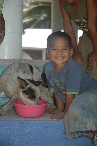 Shimpa the dog enjoying food delivered by WSPA, with his much loved friend.